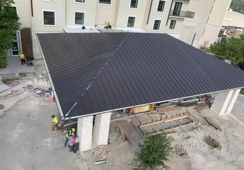 Metal roofing installation team working on a commercial building in St. Robert
